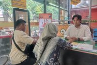 Foto : BRIPDA KRISNADI (Kemeja putih) saat melayani pembuatan SKCK kepada masyarakat.