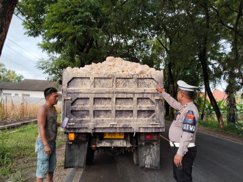 Foto: Aiptu Eddy Haryono, mengambil tindakan tegas terhadap truk bermuatan tanah sirtu yang tidak menggunakan penutup. 