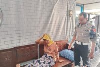 Foto: Bripka Muhammad Luthfi, anggota Tim Elang Satlantas Polres Sumenep, saat mengevakuasi warga yang pingsan di perempatan Jl. Trunojoyo, Rabu (16/4/2025) pagi. 