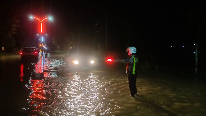 Foto: Petugas melakukan pengaturan lalu lintas di kawasan genangan air Patean dan Nambakor.
 