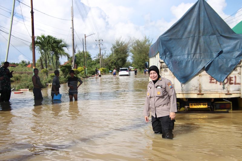 Foto: Kasi Humas Polres Sumenep, AKP Widiarti, berada di lokasi banjir di Jalan Raya Sumenep–Pamekasan saat memantau langsung evakuasi dan pengalihan arus lalu lintas, Rabu (14/5/2025).