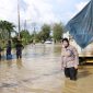 Foto: Kasi Humas Polres Sumenep, AKP Widiarti, berada di lokasi banjir di Jalan Raya Sumenep–Pamekasan saat memantau langsung evakuasi dan pengalihan arus lalu lintas, Rabu (14/5/2025).

