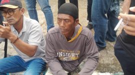 Foto: Asi (54), warga Kecamatan Dungkek, duduk di depan kantor Kejaksaan Negeri Sumenep usai menyampaikan orasi terkait dugaan penyimpangan program BSPS 2024, Kamis (22/5/2025).