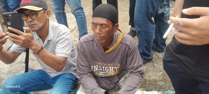 Foto: Asi (54), warga Kecamatan Dungkek, duduk di depan kantor Kejaksaan Negeri Sumenep usai menyampaikan orasi terkait dugaan penyimpangan program BSPS 2024, Kamis (22/5/2025).