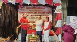 Foto: Ketua RT 18 Trunojoyo Regency, Arif Ardiansyah (baju putih), menyerahkan tumpeng secara simbolis kepada warga, Edi Haryono, pada malam tasyakuran HUT RI ke-80.