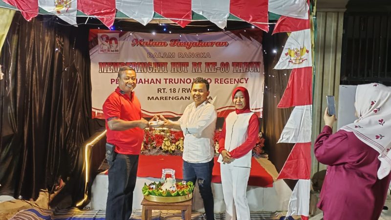 Foto: Ketua RT 18 Trunojoyo Regency, Arif Ardiansyah (baju putih), menyerahkan tumpeng secara simbolis kepada warga, Edi Haryono, pada malam tasyakuran HUT RI ke-80.