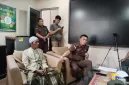 Foto: Pak Asi (berpakaian sarung dan batik) bersama Lukman Harun Biya, S.H., M.H., saat berada di Kejaksaan Agung.
