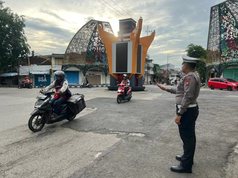Foto: Bripka Taufik Rahman, petugas Satlantas Polres Sumenep, saat mengatur arus lalu lintas di Simpang Empat Jalan Halim Perdana Kusuma, Kota Sumenep, Selasa (11/11/2025).