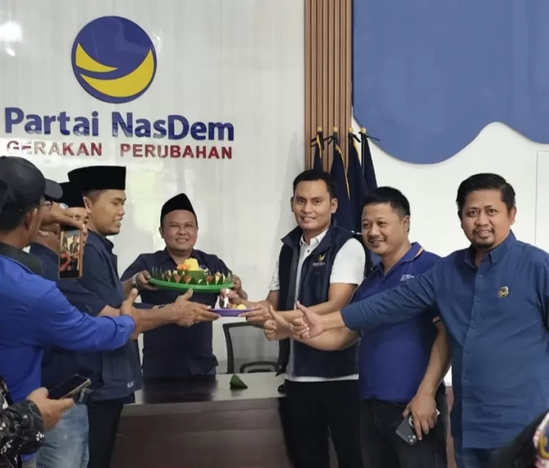Foto: Ketua DPD Partai NasDem Sumenep, Akis Jasuli (berjaket biru), bersama pengurus partai saat prosesi potong tumpeng pada peringatan HUT ke-14 Partai NasDem di Kantor DPD NasDem Sumenep, Selasa (11/11/2025).