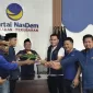 Foto: Ketua DPD Partai NasDem Sumenep, Akis Jasuli (berjaket biru), bersama pengurus partai saat prosesi potong tumpeng pada peringatan HUT ke-14 Partai NasDem di Kantor DPD NasDem Sumenep, Selasa (11/11/2025).