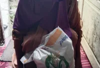 Foto: Warga Sabunten menunjukkan bantuan pangan yang diterimanya.