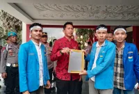 Foto: Kabag Perekonomian dan SDA Setkab Sumenep, Dadang Dedy Iskandar (tengah), menerima berkas tuntutan dari Ketua PK PMII UPI Sumenep, Diky Alamsyah (kanan), usai aksi