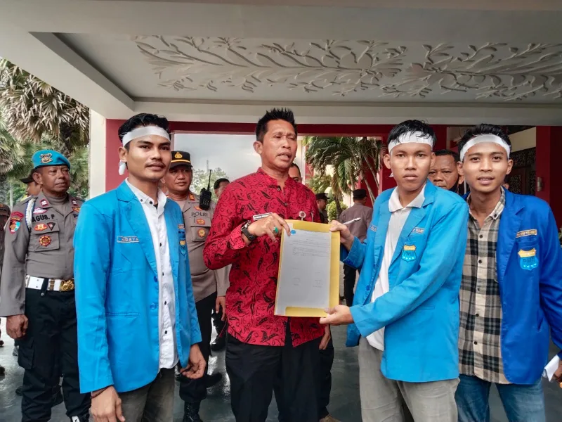 Foto: Kabag Perekonomian dan SDA Setkab Sumenep, Dadang Dedy Iskandar (tengah), menerima berkas tuntutan dari Ketua PK PMII UPI Sumenep, Diky Alamsyah (kanan), usai aksi