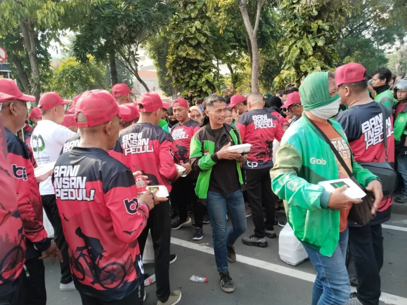 Foto: Relawan Bani Insan Peduli membagikan nasi kotak kepada para pengemudi ojek online di depan Gedung Negara Grahadi Surabaya pada rangkaian 1st Anniversary BIP.