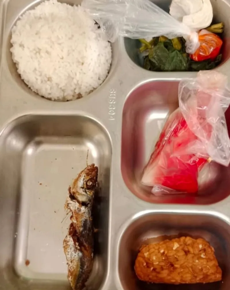 Foto: Menu Program Makan Bergizi Gratis (MBG) di salah satu sekolah di Kecamatan Dungkek, Sumenep, berisi nasi, ikan goreng kecil, tempe, sayur, sambal, dan buah yang dikemas plastik.