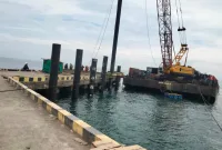 Foto: Aktivitas pekerjaan Replacement Paspel di Pelabuhan Sapudi tampak terhenti, dengan alat berat dan ponton proyek berada di sisi dermaga.