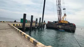 Foto: Aktivitas pekerjaan Replacement Paspel di Pelabuhan Sapudi tampak terhenti, dengan alat berat dan ponton proyek berada di sisi dermaga.