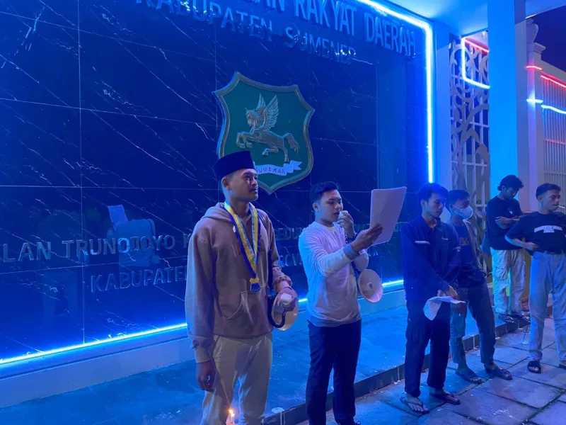 Foto: PMII UNIBA Madura menyampaikan pernyataan sikap di depan Gedung DPRD Kabupaten Sumenep, Minggu malam (11/1/2026).