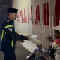 Foto: AKP Beny Kuncoro, S.Tr.K., S.I.K., Kasat Lantas Polres Sumenep, menyerahkan santap sahur kepada warga dalam kegiatan Polantas Menyapa Sahur Off The Road di Kota Sumenep.
