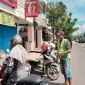 Foto: Congli mengatur arus kendaraan di depan gerai Momoyo, memastikan pengendara parkir dengan aman di Jalan Trunojoyo, Sumenep (2/4/2026).