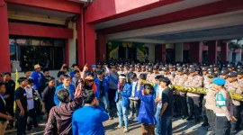 Foto: Aksi mahasiswa PMII Sumenep saat menyuarakan kritik terhadap kebijakan tembakau dengan pengawalan aparat kepolisian.