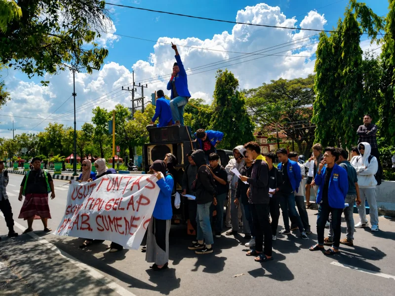 Foto: Aksi demonstrasi mahasiswa Pergerakan Mahasiswa Islam Indonesia (PMII) di jalan raya Sumenep, menyoroti dugaan skandal kredit pensiun di BRI Cabang Sumenep.
