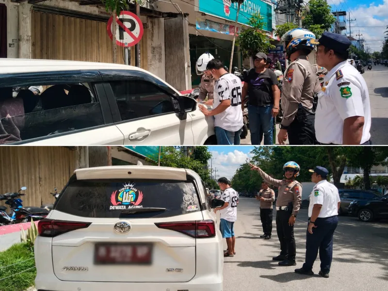 Foto: Petugas menilang mobil yang melanggar parkir di Jalan Diponegoro.