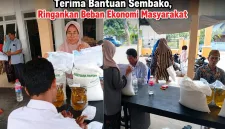 Foto: Warga Desa Essang antusias menerima bantuan sembako berupa beras dan minyak goreng dari program ketahanan pangan nasional.
