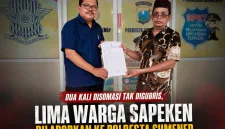 Foto: Kuasa hukum Rahman, S.H., bersama pelapor Subandrio (kanan) menunjukkan salinan laporan polisi usai melaporkan dugaan penggelapan hak atas tanah di SPKT Polresta Sumenep, Sabtu (18/7/2026).
