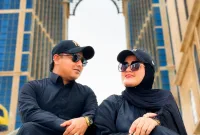 Foto: H. Yudik bersama istrinya mengabadikan momen di depan Mekkah Tower, Arab Saudi.