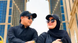 Foto: H. Yudik bersama istrinya mengabadikan momen di depan Mekkah Tower, Arab Saudi.