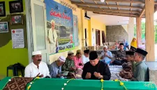 Foto: Ahsanul Qosasi, berkemeja hitam dan berpeci hitam, saat mendoakan Mbah Hosen di rumah duka.