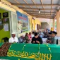 Foto: Ahsanul Qosasi, berkemeja hitam dan berpeci hitam, saat mendoakan Mbah Hosen di rumah duka.