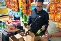 Foto: Petugas saat memeriksa dan mengamankan sejumlah botol minuman keras di sebuah toko kelontong di Bangselok, Sumenep.