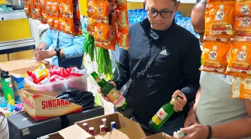 Foto: Petugas saat memeriksa dan mengamankan sejumlah botol minuman keras di sebuah toko kelontong di Bangselok, Sumenep.