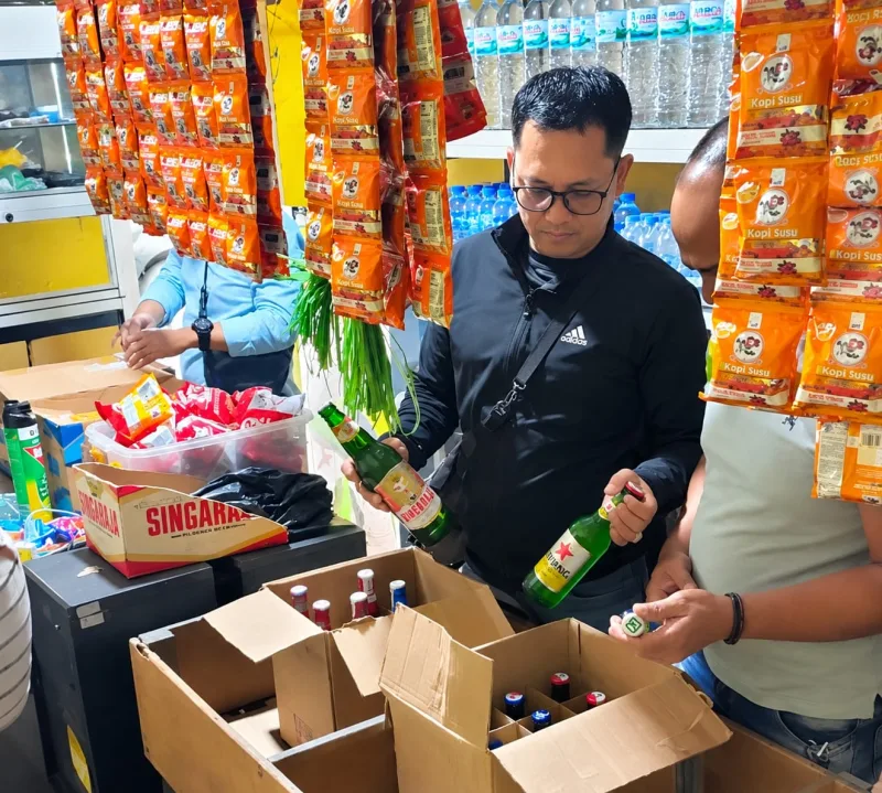 Foto: Petugas saat memeriksa dan mengamankan sejumlah botol minuman keras di sebuah toko kelontong di Bangselok, Sumenep.